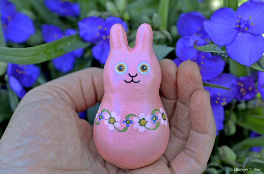Maisie Maybunny, original, one-of-a-kind miniature handmade mauve-pink floral bunny rabbit art doll figurine by artist Elizabeth Ruffing with blue purple spiderwort flowers
