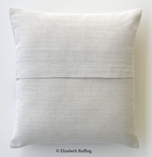 Oatmeal-colored cotton, decorative throw pillow with an envelope closure