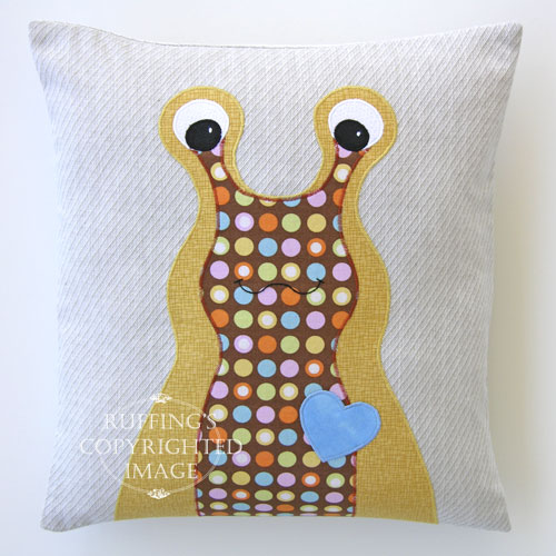 Gold, Brown with Polka Dots, Light Blue, and Oatmeal Hug Me Slug Decorative Pillow by Elizabeth Ruffing