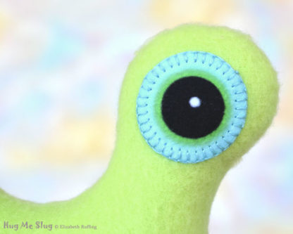 Hug Me Slug, Pear Green , Teal Heart, 12 inch, handmade stuffed animal banana slug art toys by artist Elizabeth Ruffing, eye detail