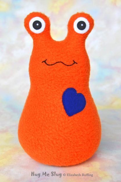 Handmade Orange Fleece Hug Me slug plush toy, royal blue heart, 7 inches, by artist Elizabeth Ruffing
