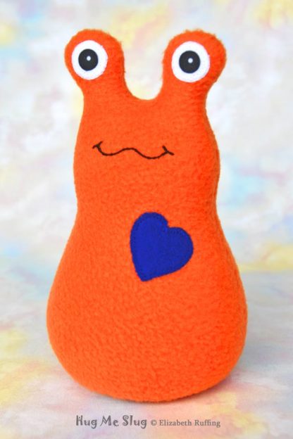 Handmade Orange Fleece Hug Me slug plush toy, royal blue heart, 7 inches, by artist Elizabeth Ruffing