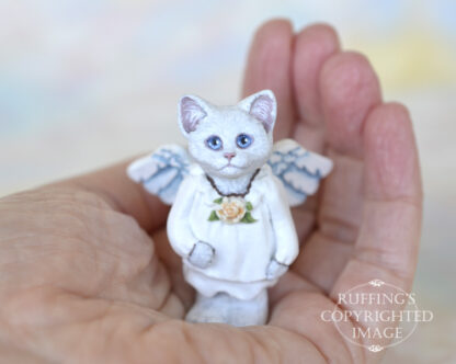 White cat angel with blue eyes and peach rose at neck