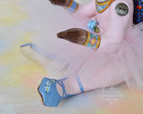 Blue ballet slippers worn by a Siamese car art doll in a lavender-pink tutu