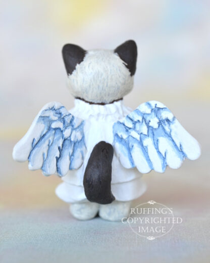 A bi-color ragdoll kitten with angel wings back view