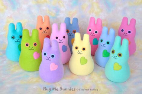 Apple green, soft light orange, lavender, pink, blue, light yellow, and turquoise stuffed fleece rabbits, all smiling