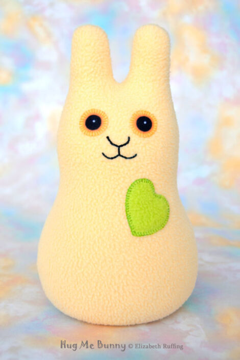 A soft yellow fleece bunny with a apple green heart and gold eyes