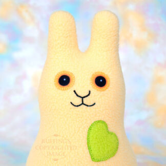 A soft yellow fleece bunny with a apple green heart and gold eyes