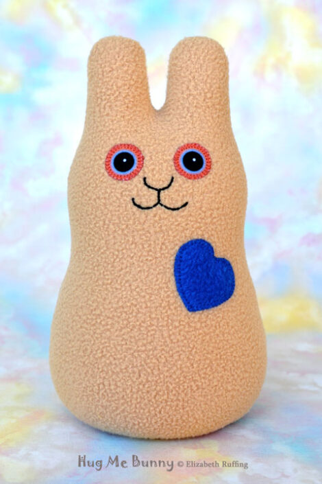Smiling camel fleece bunny with a royal blue heart