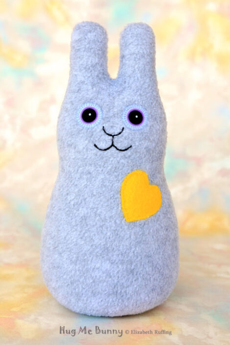 Smiling heather gray bunny with a yellow heart