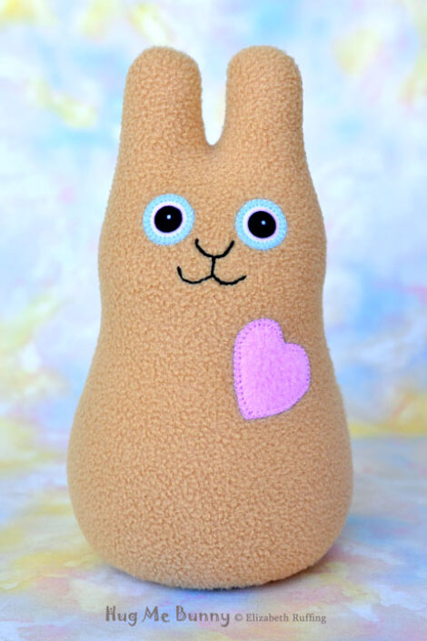 Smiling camel fleece bunny with a lavender-pink heart