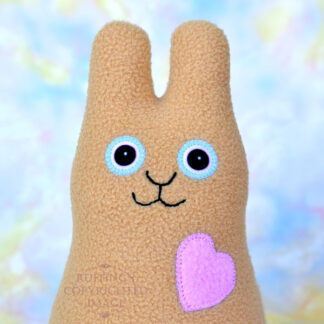Smiling camel fleece bunny with a lavender-pink heart