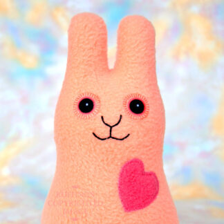 Smiling soft light orange fleece bunny with a coral heart