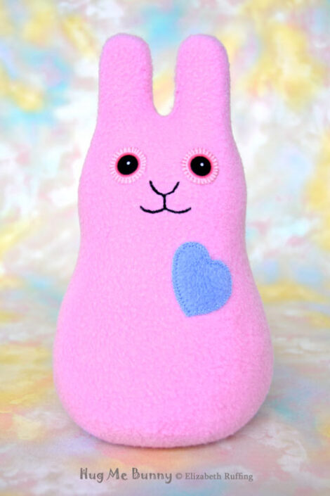 Smiling lavender-pink fleece bunny with a cornflower blue heart