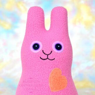 Smiling mauve pink bunny with a coral orange heart