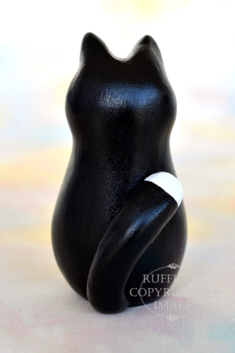Black-and-white-tuxedo kitten with a white-tipped tail